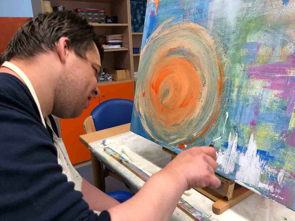 Ein Beschäftigter im BFB malt ein Bild